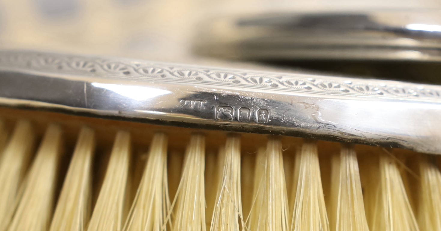 A George V silver mounted five piece mirror and brush set by A & J Zimmerman, five other silver mounted brushes, mirror and jar and a plated lighter.